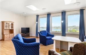 sala de estar con sillas azules y TV en Beautiful Apartment In Egersund With Kitchen en Egersund