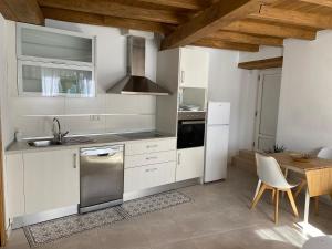 a kitchen with white appliances and a wooden ceiling at Casa de la abuela Elisa - Ribeira Sacra - Cañones del Sil - Caurel in Quiroga