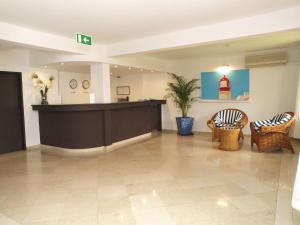 eine Lobby mit Rezeption und Stühlen in der Unterkunft Portimão Center Hotel by Umbral in Portimão + 75 Fotos