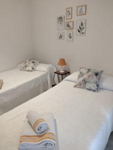 コルドバにあるPatios con encantoのベッドルームにタオル付きのベッド2台が備わります。