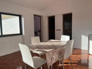 a dining room with a marble table and white chairs at Villa Kasa in Durrës