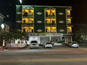 a green building with cars parked in front of it at Green Paradise in North Pattaya