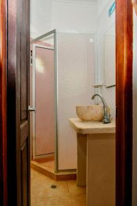 a bathroom with a sink and a shower at Hotel Isla Mágica in Coveñas