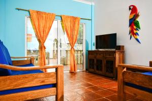 a living room with a tv and a large window at Hotel Isla Mágica in Coveñas