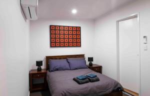 een slaapkamer met een bed met twee blauwe kussens erop bij 4 Bedrooms, 2 Bathrooms in Alice Springs in Alice Springs