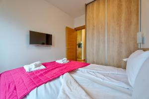 a bedroom with a bed with a pink blanket on it at S35, vila Elsa 1 in Zlatibor