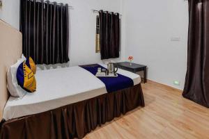 a bedroom with a large bed with a table on it at Hotel O Rudraksh Residency in Bhilai