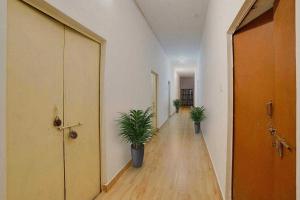 an empty hallway with two potted plants on the floor at Hotel O Rudraksh Residency in Bhilai