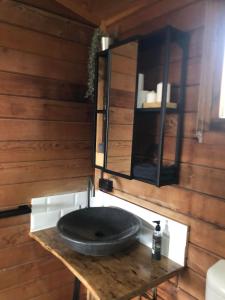 baño con lavabo negro en una pared de madera en Lappi Farm, en Berridale