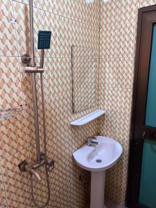 La salle de bains est pourvue d'un lavabo et d'une douche. dans l'établissement Ouedraogo Property Management, à Ouagadougou