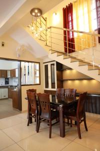 a dining room with a table and chairs and a staircase at Pullad in Aranmūla