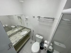 a white bathroom with a sink and a toilet at Spazzio diRoma com acesso ao Acqua Park, Splash e Slide in Caldas Novas