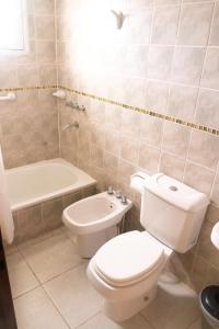 a bathroom with a toilet and a tub and a sink at Tranqueras Lodge in El Chalten