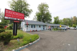 a building with a sign in a parking lot at Brookside Inn & Cottages in Saco