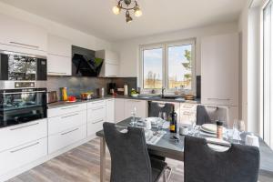 a kitchen with a table and chairs in it at Apartment "Sanddorn" - Haffresidenz in Garz