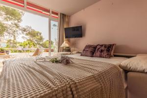 ein Schlafzimmer mit einem großen Bett mit einem großen Fenster in der Unterkunft Acogedor Bungalow Park Florimar in Tarragona