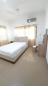 1 dormitorio con 1 cama blanca en una habitación en 10mins to airport malls wifi no data en Accra