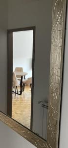 an einer Wand hängt ein Spiegel mit einem Tisch in der Unterkunft Sunny apartment in Vršac