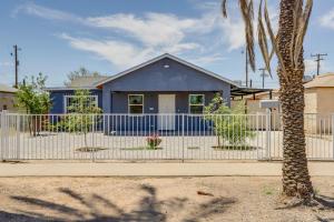 a blue house behind a fence with a palm tree at Pet-Friendly Phoenix Vacation Rental Near Downtown in Phoenix