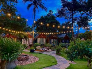 a garden with a string of lights and a patio at Garden Homestay in Di Linh
