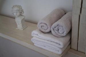 ein Regal mit Handtüchern und einer Statue im Bad in der Unterkunft Apartmány Rudík in Železná Ruda