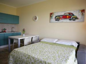 アローナにあるCasa Ierardi - Appartamento Arona Bellavistaのベッドルーム1室(ベッド1台、テーブル、車の絵画付)