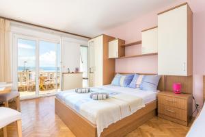 Schlafzimmer mit einem großen Bett und Meerblick in der Unterkunft Apartments by the sea Brela, Makarska - 18356 in Brela