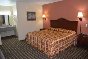 a hotel room with a bed and a sink at Grand Palace Inn in Huntsville