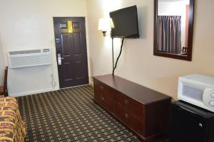 a hotel room with a bed and a tv at Grand Palace Inn in Huntsville