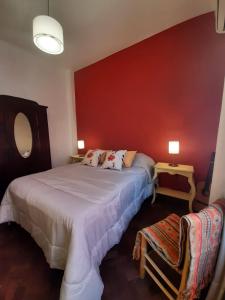 1 dormitorio con 2 camas y pared roja en CasaOma en Río Cuarto