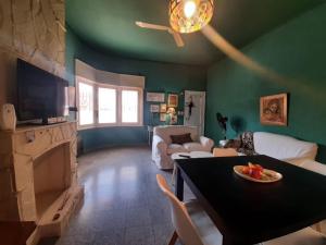 ein Wohnzimmer mit grünen Wänden und einem Tisch mit einem Obstteller in der Unterkunft CasaOma in Río Cuarto