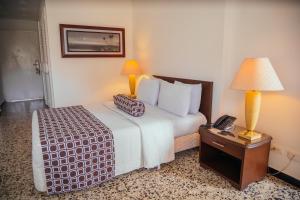 a hotel room with a bed and a phone on a table at Hotel Estación by Destino Pacifico in Buenaventura
