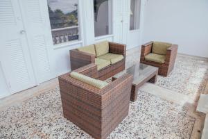 twee rieten stoelen en een salontafel op een veranda bij Hotel Estación by Destino Pacifico in Buenaventura