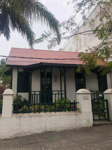 uma casa com um telhado vermelho e um alpendre em Villa Tamen - Colonia em Colónia do Sacramento