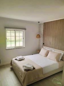 a bedroom with a large white bed with a window at Fazenda Valley in Santa Cruz das Flores