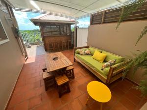 a living room with a green couch and a table at Kazadoli in Bois-Neuf