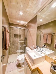 La salle de bains est pourvue d'un lavabo, de toilettes et d'une douche. dans l'établissement Condomínio fechado a 11 minutos a pé do Centrinho, à Campos do Jordão