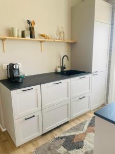 a kitchen with white cabinets and a sink at Stylish cottage with hot tub in Stóri-Ás