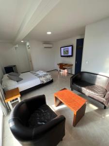 Cette chambre comprend un lit, un canapé et une table. dans l'établissement Hotel Boutique Santa Ana, à Cartago