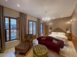 1 dormitorio grande con 1 cama y 1 sofá rojo en Villa de luxe L'MNAM en Marrakech