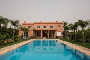 a large swimming pool in front of a house at Villa de luxe L'MNAM in Marrakech
