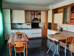 een keuken met witte kasten en een tafel en stoelen bij B&B Lumière in Reggio di Calabria