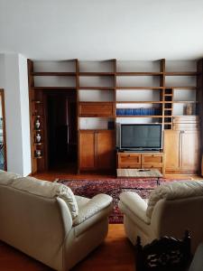 een woonkamer met 2 banken en een flatscreen-tv bij B&B Lumière in Reggio di Calabria
