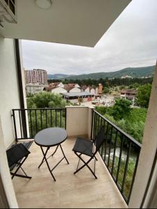 a balcony with a table and chairs and a view at Tregu fatoni prizren apartment 3bedroom in Prizren