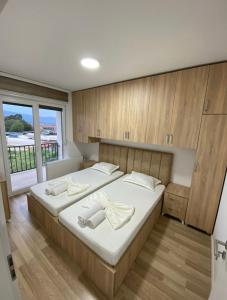 Schlafzimmer mit einem großen Bett und Holzschränken in der Unterkunft Tregu fatoni prizren apartment 3bedroom in Prizren