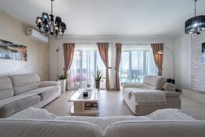 a living room with two couches and a table at Villa Hacienda in Budva