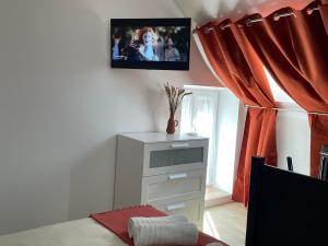 1 dormitorio con tocador y TV en la pared en « le Tilleul » entre Loire et Châteaux, en Vineuil