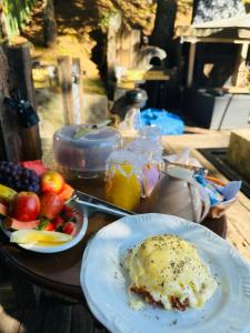 a table with two plates of food and fruit on it at Chalét-Casa e Bangalo- Villa-Jacuzzi-Sauna-Lareira-Privativo in Campos do Jordão