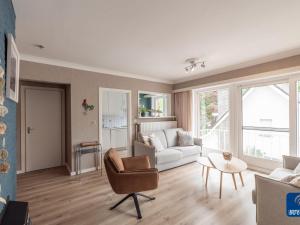 uma sala de estar com um sofá e uma cadeira em Dante 0103 furnished apartment with 2 bedrooms em De Haan