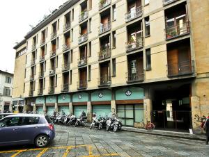 フィレンツェにあるApartments Florence Via Verdiの正面にたくさんのバイクが停まった建物
